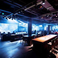 パブリックビューイングで大型ディスプレイの試合を観戦する人たちの写真