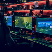 赤いライティングのゲーミングルーム｜eスポーツ大会風の競技環境の写真