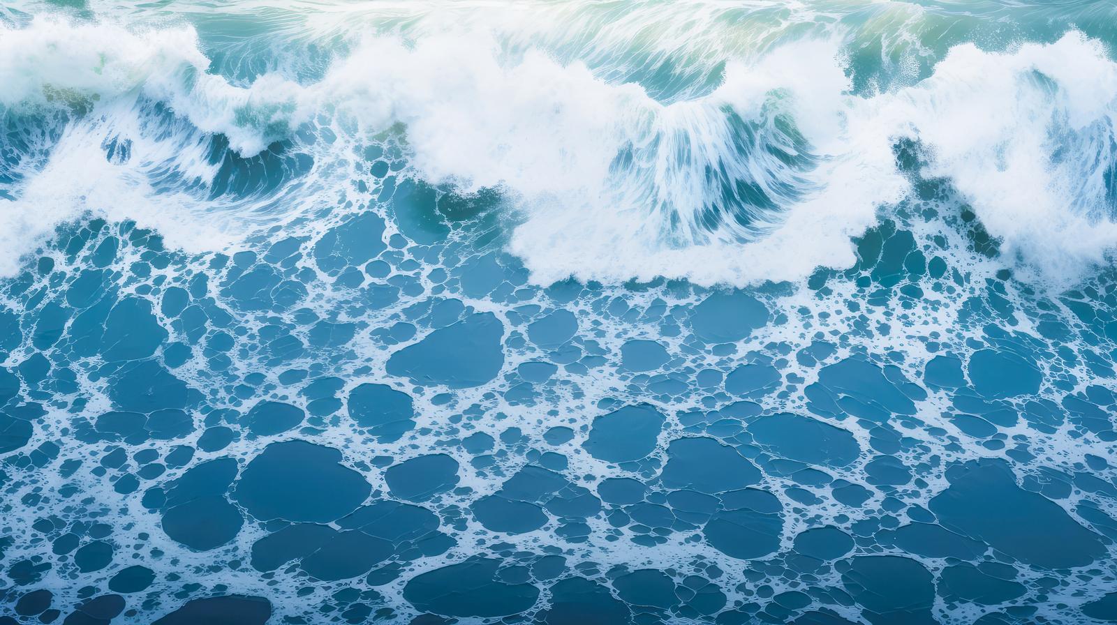 海岸に打ち寄せる複数の高波と白い波しぶきが立ち上る様子