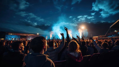 大盛りあがりのフェス会場でステージに向かって手を上げる観客