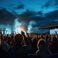 ステージ上のパフォーマーを見つめるライブの観客たちの写真