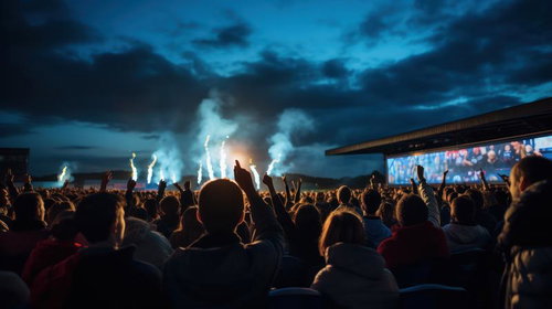 ステージ上のパフォーマーを見つめるライブの観客たち