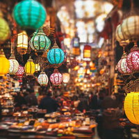 人で混み合うグランバザール市の屋台とランタンの写真