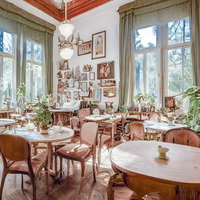 おしゃれなカフェの明るい店内空間。木製のテーブルと椅子の写真