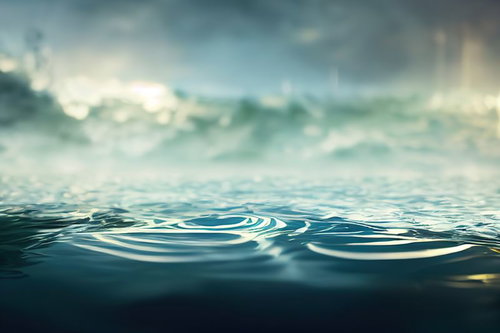 青い海面に広がる波紋と曇り空が映り込む水面