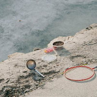 砂場での遊び道具とラケット、バケツやシャベルなどの子供向けおもちゃの写真