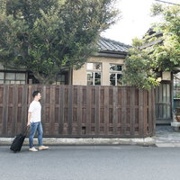 古民家にやってきた外国人観光客の男性とキャリーケースの写真
