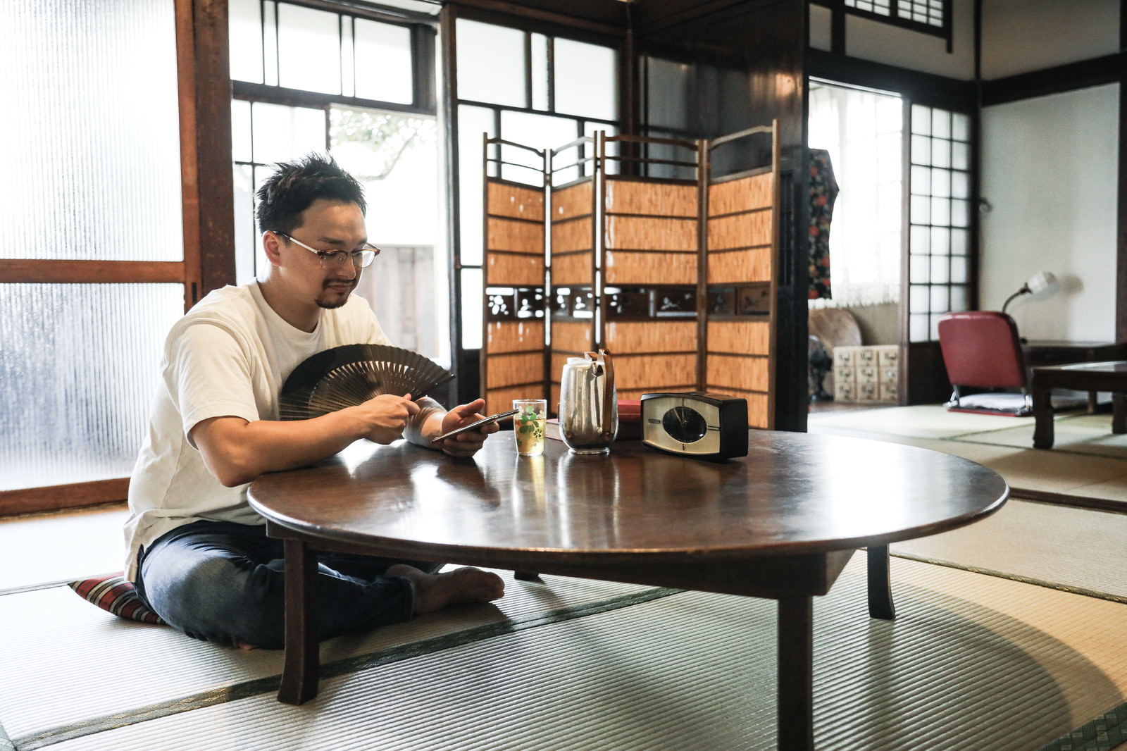 古民家の畳の和室で座卓の前に座ってくつろぐ外国人男性［モデル：Max_Ezaki］