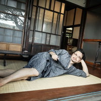 古民家の縁側で横になってくつろぐ外国人男性の写真