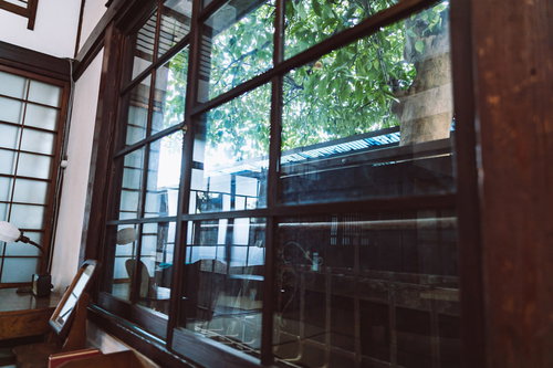 古民家の和室のガラス窓から見える庭の木漏れ日