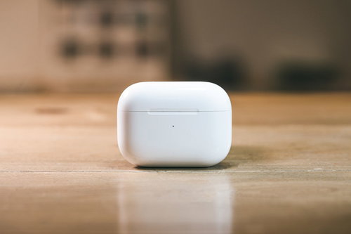 木製テーブルに置かれた白いAirPodsケース