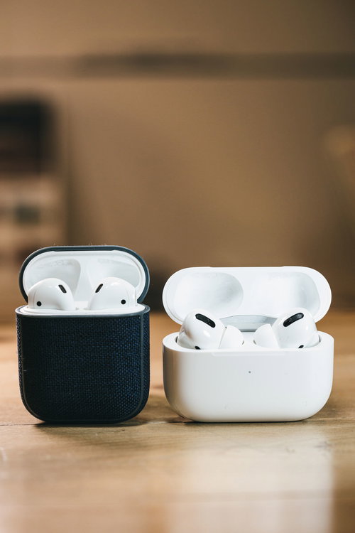白いAirPods Proと黒いケースのAirPods、卓上に並べて配置