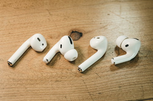 木目のテーブルに並べられたAirPodsとAirPods Pro