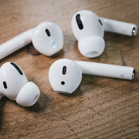 木の机に置かれたワイヤレスイヤホンAirPodsの写真