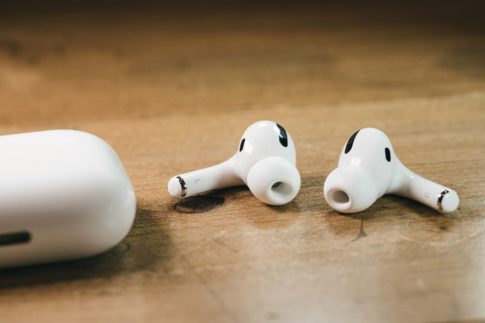木製のテーブルに置かれたAirPods Proと充電ケース