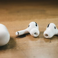 木製テーブルの上に配置されたAirPods Proの写真