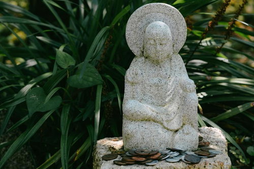 小さな石仏の足元の置かれたお賽銭