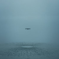 水上で浮遊するドローンと水面への反射、霧の悪天候での飛行の写真