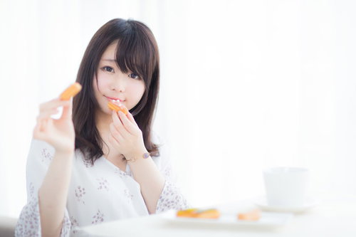 ひとつだけならあげてもいいよ、エクレアを手に持つ女性