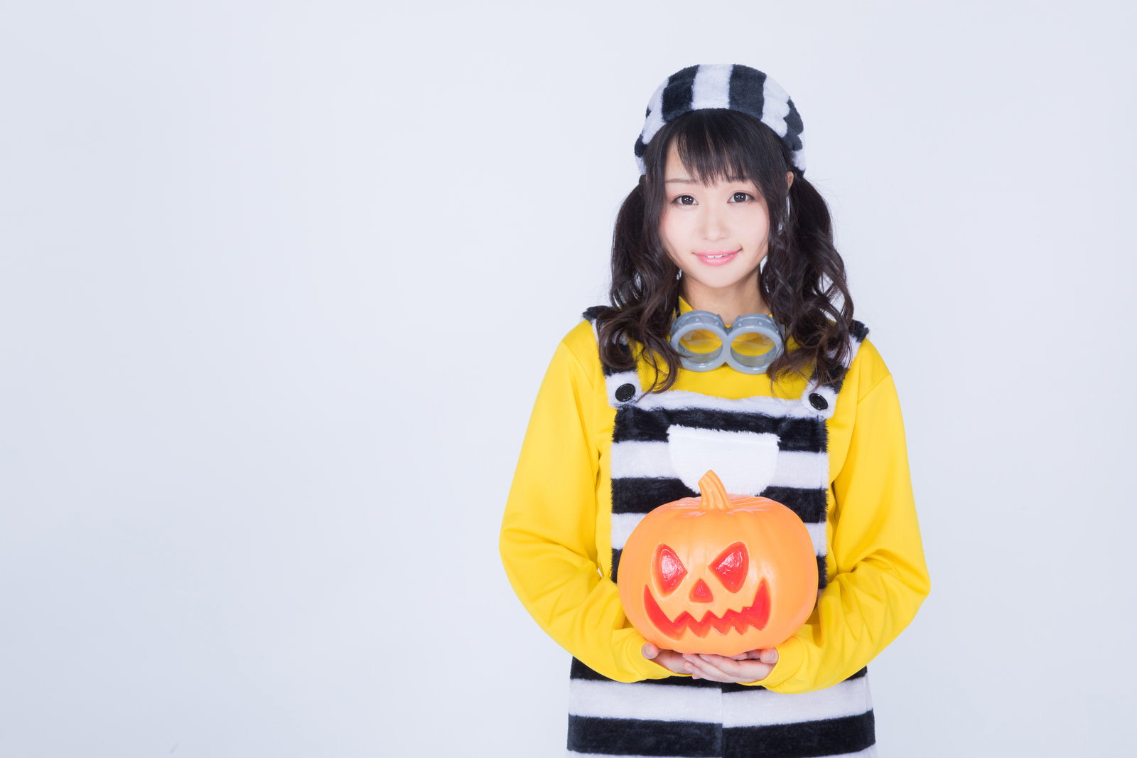 ハロウィンの仮装をしてかぼちゃを持つ女性［モデル：茜さや］