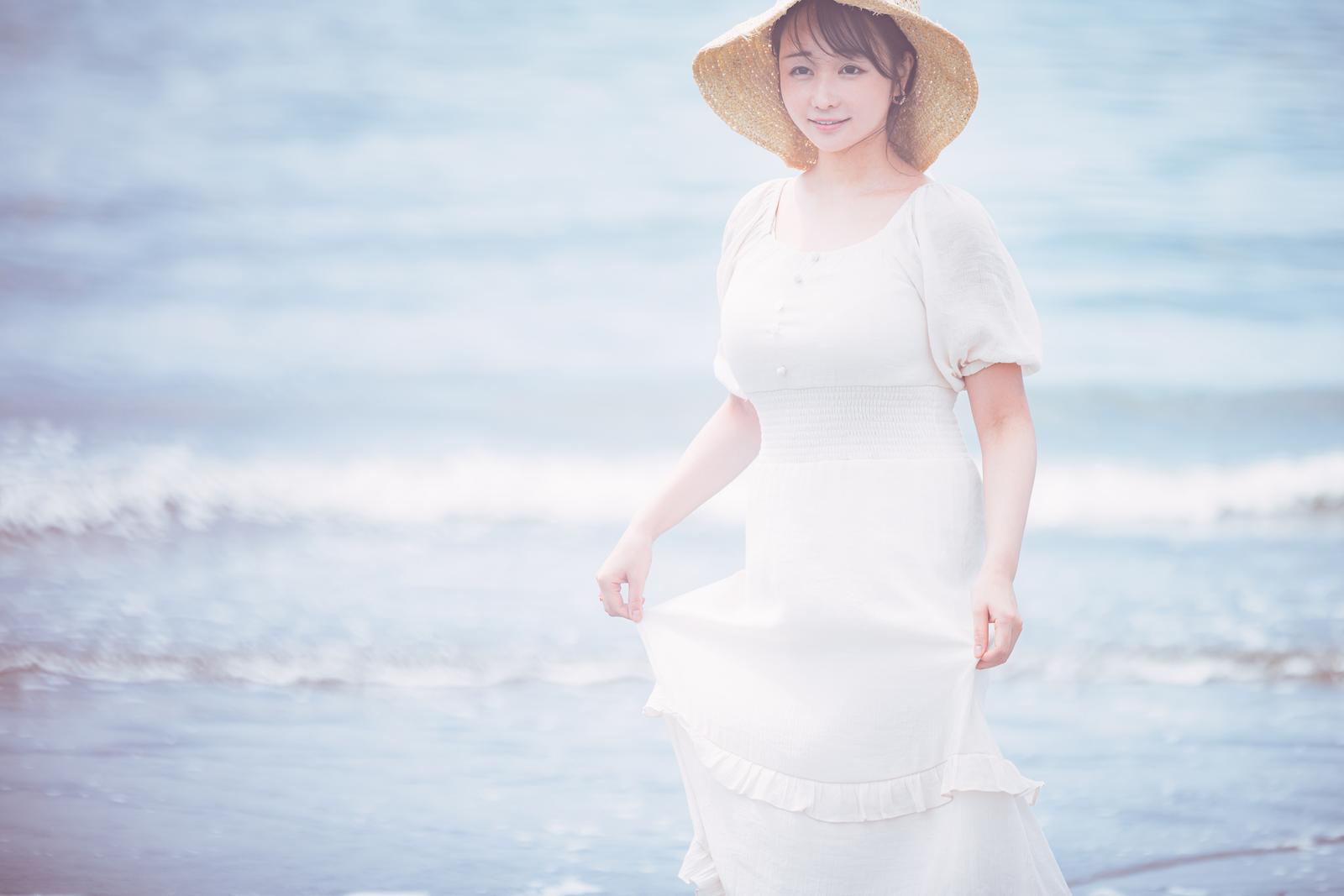 波打ち際で麦わら帽子と白いワンピースを着た女性のポートレート［モデル：茜さや］
