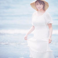 波打ち際で白いワンピと麦わら帽子を着た女性の写真