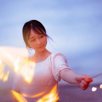 夏の思い出を灯す手持ち花火を楽しむ女性のポートレートの写真