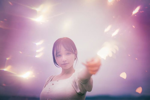 手持ち花火の煌めきを楽しむ白い服の女性の夏の夜