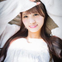ソファーに横たわって日差しを手で遮る女性の写真
