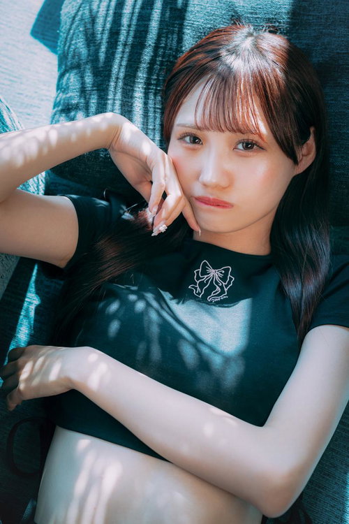 ソファーに横たわりこちらを見つめる若い女性