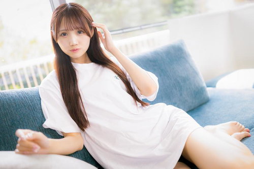 白いTシャツの女性がソファーでくつろぐ穏やかなひととき