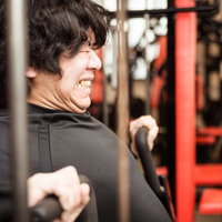 スポーツジムのチェストプレスで大胸筋を鍛えるトレーニーの写真