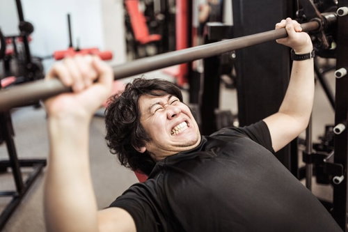 インクラインベンチプレスで大胸筋上部を鍛える男性トレーニー