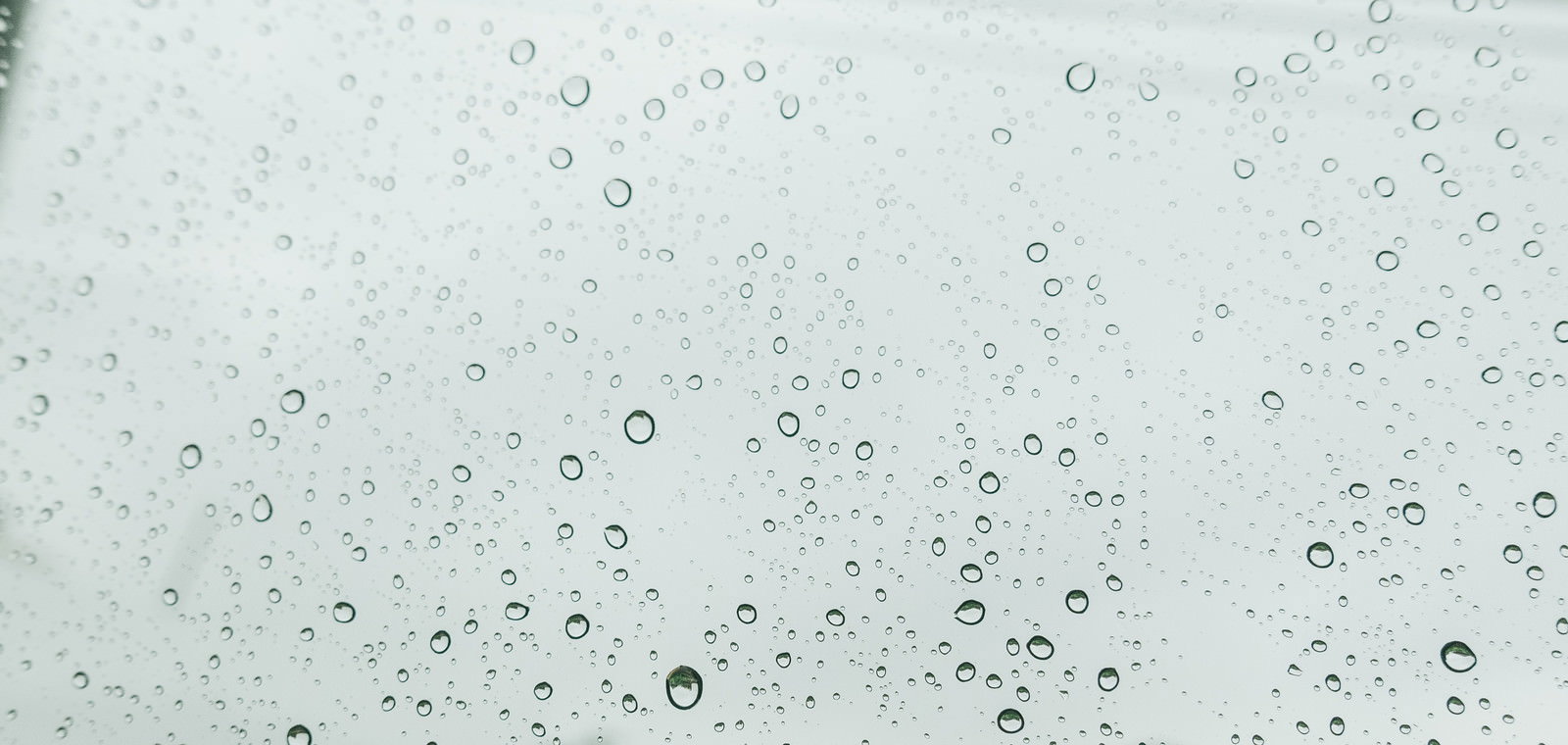 窓ガラスに付いた大小様々な雨の水滴