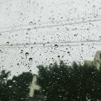夕方にかけて窓についた雨粒｜梅雨時期の雨天風景の写真
