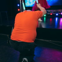 ステージ上で歌う女性アイドルにペンライトを向ける男性ファンの写真