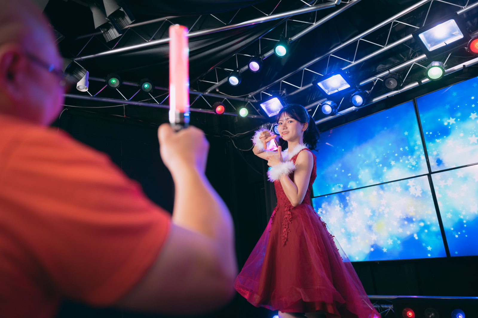 ステージでペンライトを掲げ、アイドルの視線をもらうファンの後ろ姿［モデル：モデルリリース あまやん］