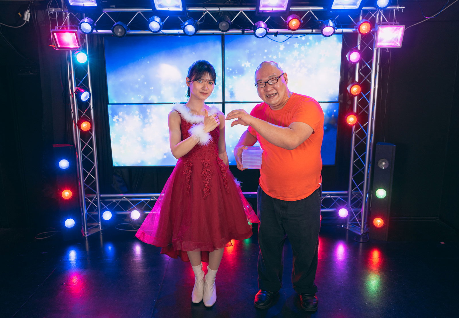 ステージ上でアイドルに両手を広げてハートを作る赤いTシャツの男性ファン［モデル：モデルリリース あまやん］