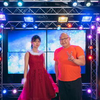 ステージ上でアイドルとツーショットを撮るファンの写真