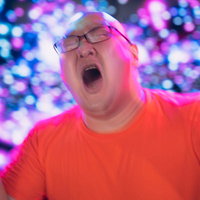 涙しながらペンライトを振るファンの男性、ライブステージで熱狂的に応援の写真