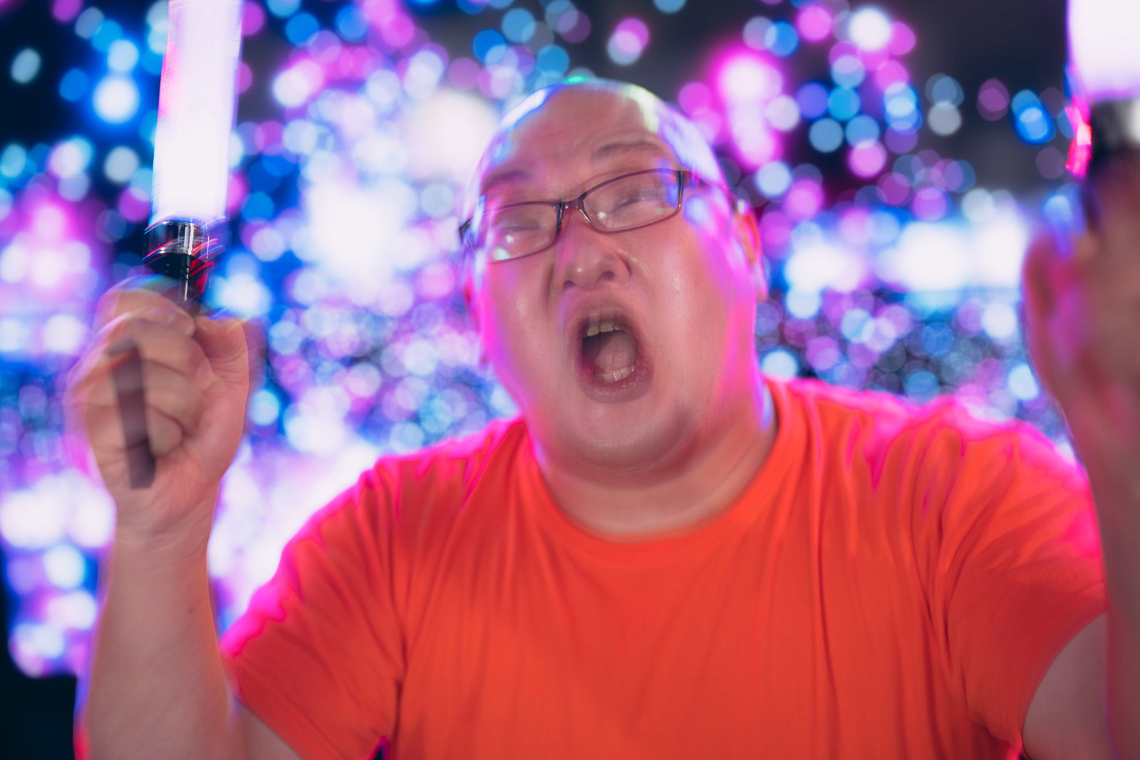 ペンライトを掲げて熱狂的に声援を送る男性ファン［モデル：あまやん］