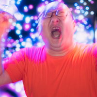 ペンライトを掲げて熱狂的に応援するデブ男性の写真