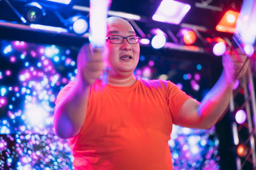 ペンライトを掲げて応援する男性のライブ会場での熱狂的な推し活