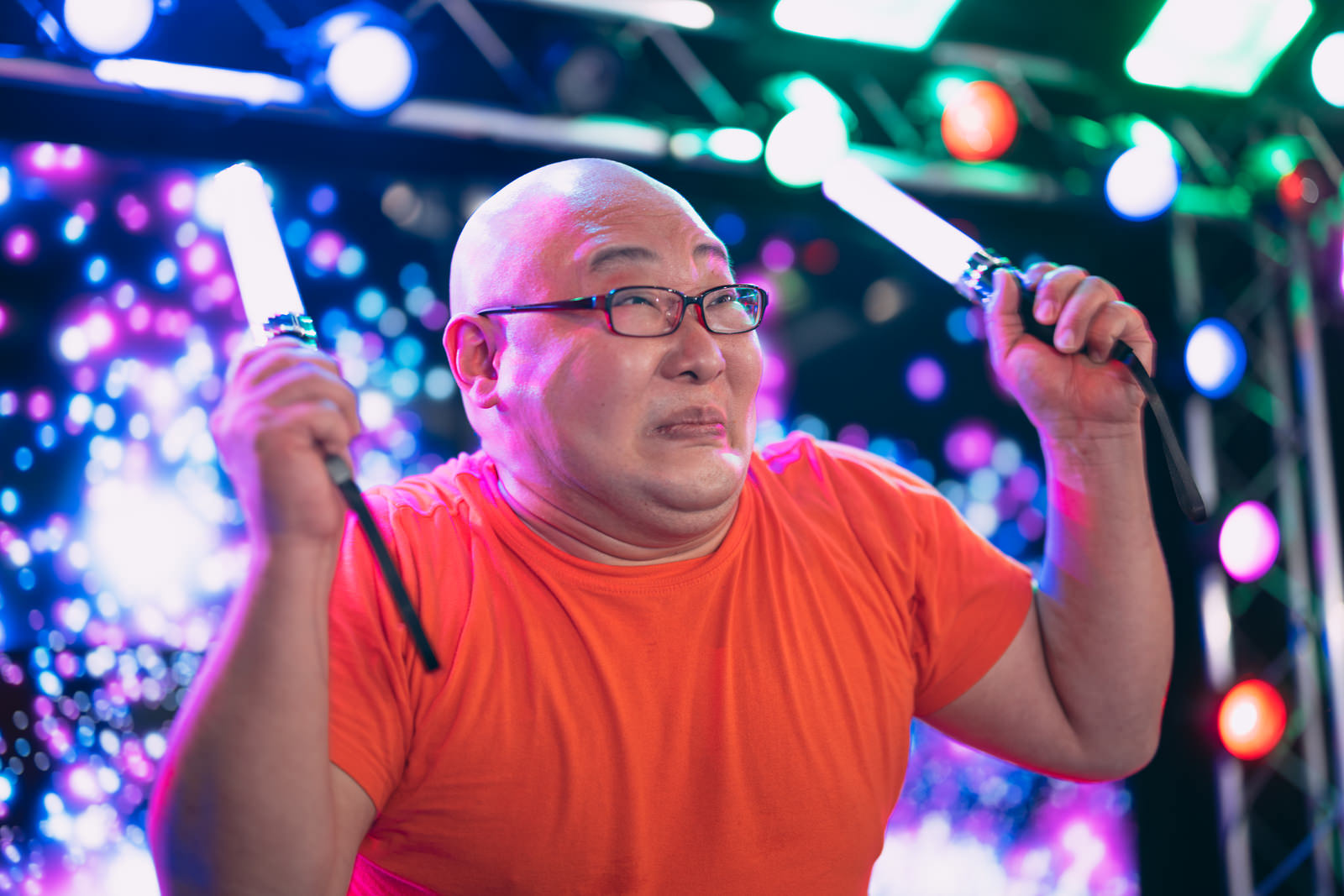 ペンライトを両手で掲げる熱狂的なファン男性［モデル：あまやん］