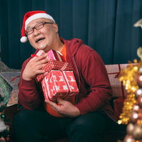 クリスマスってサイコーとニッコニコの男性がプレゼントを持つの写真