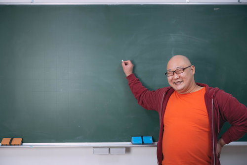 満面の笑みで黒板の前に立つ授業をするアンバサダー