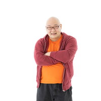 焼き芋カラーの服を着て腕を組み考える男性の写真