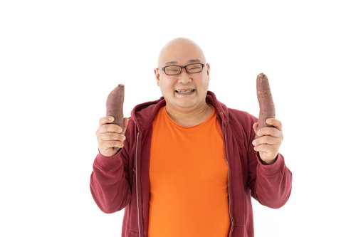 左手に焼き芋、右手にも焼き芋で笑顔の男性