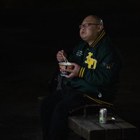 カップ麺を食べて眼鏡が曇る男性の夜間の情景の写真