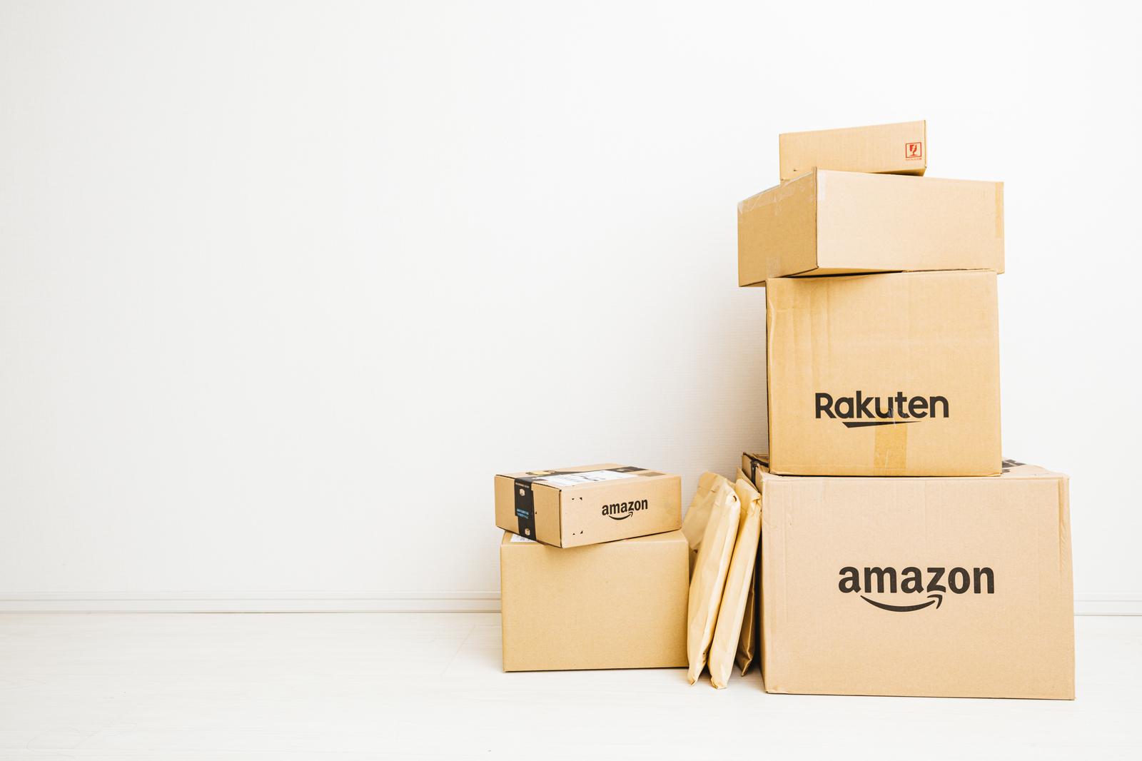 Amazonと楽天のダンボール箱が積み重ねられた配送荷物